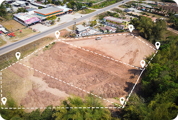 Aerial view of a cleared construction site with marked property boundaries and location pins.