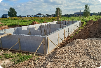 Concrete foundation walls being installed on a residential construction site.